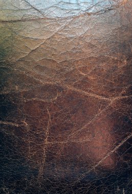 Görünür çatlaklar ve doğal aşınmalarla eski kahverengi deri dokuların yakın çekimi. Tasarım projeleri, döşeme kataloğu veya deri kataloglarında kullanım için ideal arkaplan, materyal referansı veya yüzey ayrıntısı