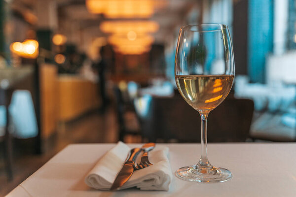Glass of White Wine on Restaurant Table. Elegant Dining Atmosphere. High quality photo