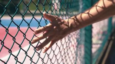 Şehir Basketbol Sahasında Metal Çitlere Dokunmak. Street Sport ve City Vibes. Yüksek kaliteli FullHD görüntüler