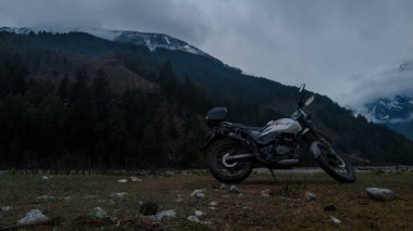Uttarakhand, India - April 7th, 2021 : Motorbiker travelling, autumn day, motorcycle off road, the driver stands with open arms to the side, to meet a new day, adventurer,