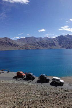 Ladakh, India - August 24th, 2022: SUV car at Pangong Lake, world's highest saltwater lake, offroading in mountains of Ladakh.
