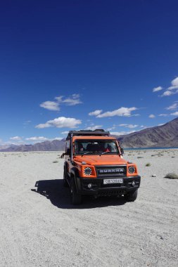 Ladakh, India - August 24th, 2022: SUV car at Pangong Lake, world's highest saltwater lake, offroading in mountains of Ladakh.