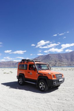 Ladakh, India - August 24th, 2022: SUV car at Pangong Lake, world's highest saltwater lake, offroading in mountains of Ladakh.