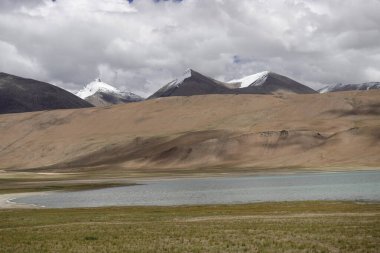 Ladakh, India - August 24th, 2022: SUV Car 4x4 In Mountains ove a Beautiful Lake in Ladakh, Tso Moriri Lake