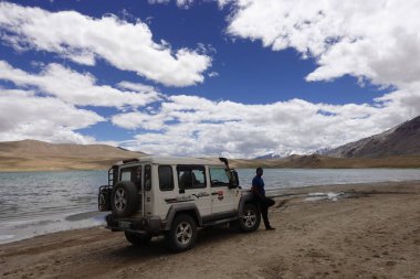 Ladakh, India - August 24th, 2022: SUV Car 4x4 In Mountains ove a Beautiful Lake in Ladakh, Tso Moriri Lake