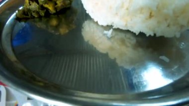 Çiçekli yemek takımında pirinç, dal ve sabzi ile turşu servis edilir. Majuli.