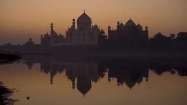 Taj Mahal 'de şaşırtıcı bir gün doğumu ve suda yansıması, Agra.