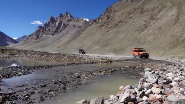 Filmación Suv Coche Moviéndose Sobre Agua Rodeado Montañas — Vídeos de Stock