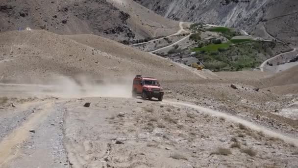 橘红色越野车在山路上扬尘行驶的镜头 — 图库视频影像