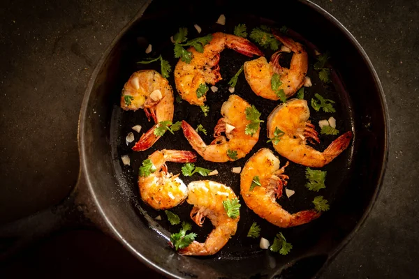 a cast iron skillet with gilled shrimp