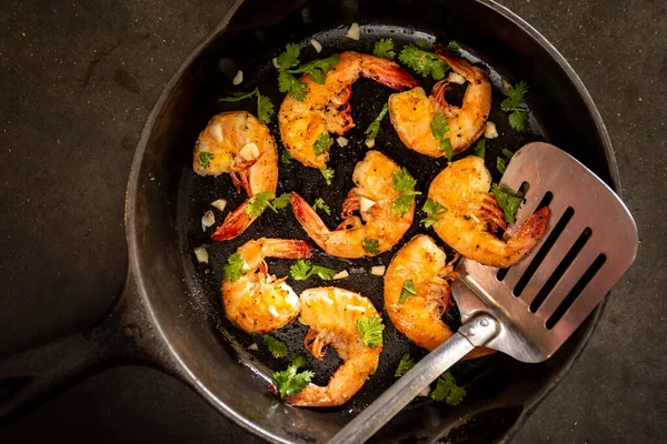 a cast iron skillet with gilled shrimp