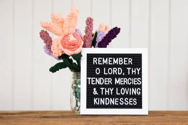 a bible verse on a sign board with three jars of purple flowers