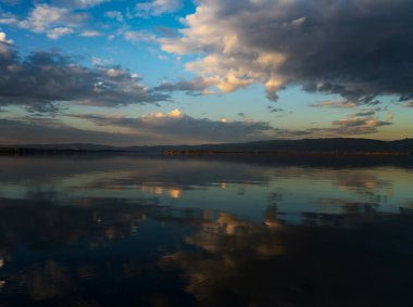 Autumn landscape. Lake water surface with reflection of clouds in the water