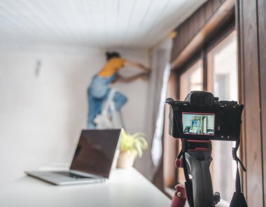 Camera on tripod shooting vlog about renovating house, lifestyle concept