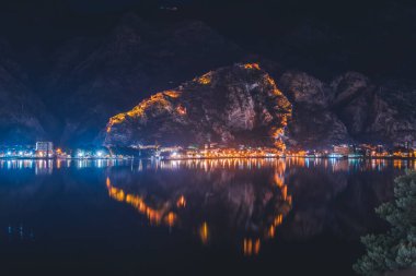 Güzel gece manzarası. Karadağ 'ın Kotor kentinde körfeze yansıyan eski bir kale var. Adriyatik Deniz Seyahati