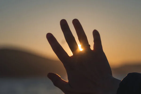 夕阳西下 一个女人的手掌的手指间的太阳 落在海滨 — 图库照片