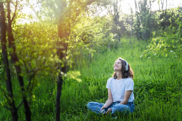 Молодая Счастливая Женщина Слушает Музыку Наушниках Сидя Зеленой Траве — стоковое фото