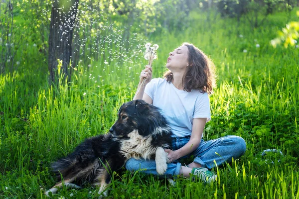 Jonge Gelukkig Vrouw Zitten Het Gras Met Haar Hond Blazen — Stockfoto