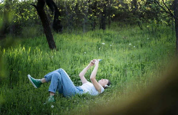 티셔츠를 정원의 잔디에 스마트폰 화면을 낙천적 — 스톡 사진
