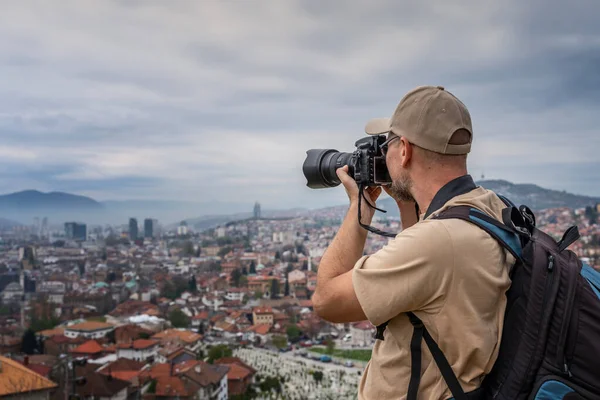 バルカン半島への旅行中にカメラで写真を撮るリュックを持つ大人の若い男性旅行者 — ストック写真