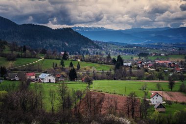 Dağların ve köyün yeşil tarlalarının manzarası. Bosna 'nın kırsal kesimleri, güzel manzaralar.