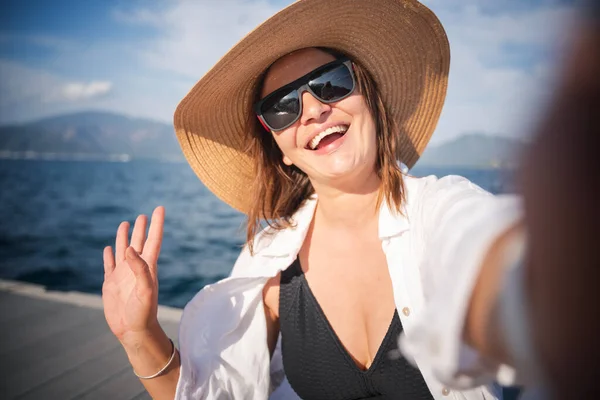 Woman Hat Sunglasses White Shirt Sitting Pier Seashore Making Selfie — Stock Photo, Image