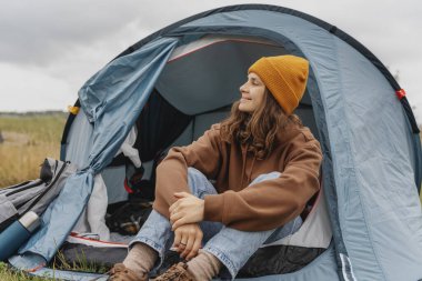 Çadırda gezen neşeli genç bir kadın. Yürüyüş ve yürüyüş konsepti