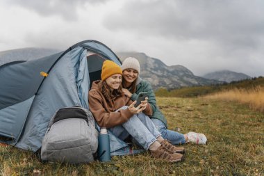 Çadırda gezen neşeli lezbiyen kızlar. Gezinti ve yürüyüş.
