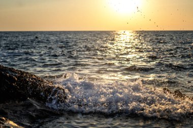 Gün batımında kıyıya vuran deniz dalgaları. Güzel deniz arka planı