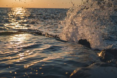 Gün batımında kıyıya vuran deniz dalgaları. Güzel deniz arka planı