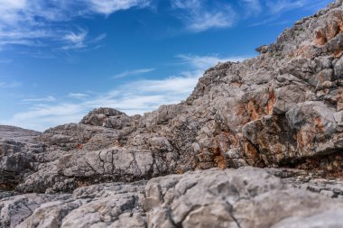 Bulutlu mavi gökyüzüne karşı gri taşlar, doğa arkaplan kavramı
