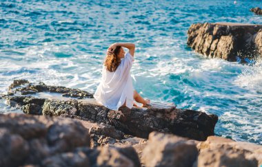 Beyaz gömlekli, neşeli, rahat genç bir kadın hayatın harika bir anının tadını çıkarıyor.