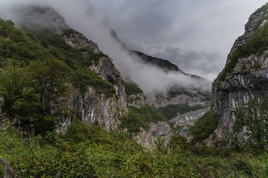 Dağların yamaçlarında sis, bulutlu havada güzel bir dağ manzarası.