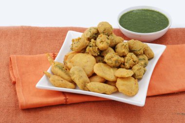 İzole edilmiş havza Pakora domates ketçaplı, popüler Hint ya da Pakistan sokak yemekleri beyaz arka planda