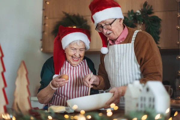 Happy seniors baking the Christmas cakes together.