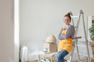 Evinin tadilatı sırasında mola veren genç ve mutlu bir kadın..