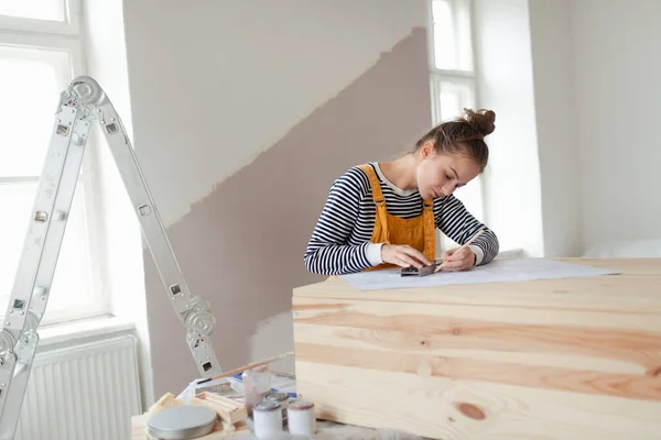 快乐的年轻女人在她的房子里重新做木柜 重复使用材料和可持续生活方式的概念 — 图库照片