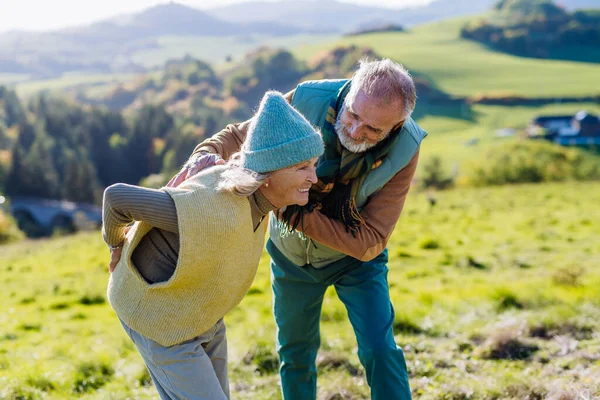 Seniorin Mit Rückenschmerzen Beim Herbstspaziergang Ihr Mann Kümmert Sich Sie — Stockfoto