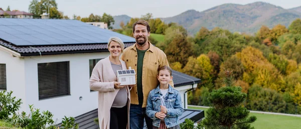 Szczęśliwa Rodzina Trzyma Papierowy Model Domu Panelami Słonecznymi Alternatywna Energia — Zdjęcie stockowe