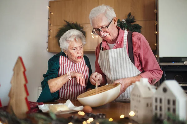 幸せな高齢者ベーキングクリスマスケーキ一緒に家で — ストック写真