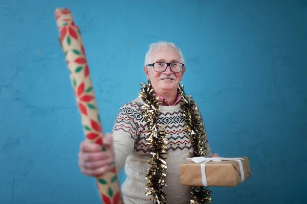 Portrait Happy Senior Man Holding Christmas Gift Wrapping Paper Studio — Stock Photo, Image