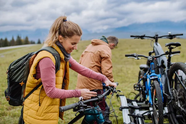 自然の中で自転車に乗る準備をしている若い家族は 車のラックから自転車を出します 健康的なライフスタイルと移動活動の概念 — ストック写真