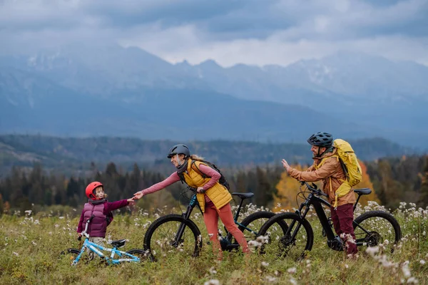 秋の自然の中で 自転車で小さな娘と若い家族 健康的なライフスタイルの概念 — ストック写真