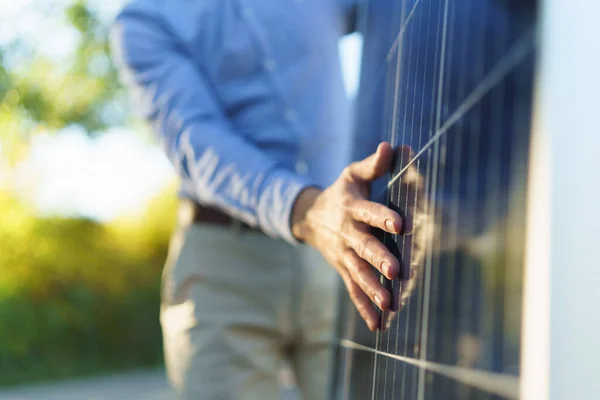 持太阳能电池板的商人站在花园外的特写镜头 — 图库照片