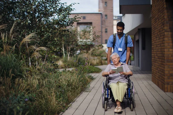 Смотритель Толкает Пожилую Женщину Инвалидном Кресле Улице — стоковое фото