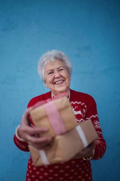 Portrait Happy Senior Woman Holding Gift Front Blue Background — Stock Photo, Image