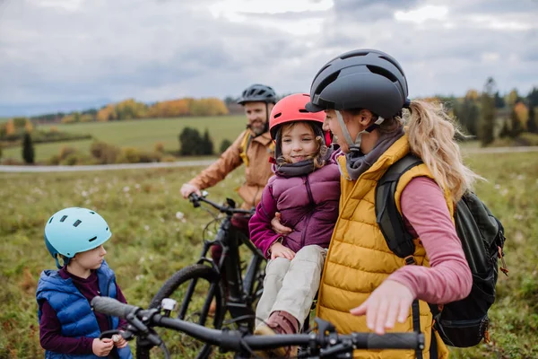 自然の中で自転車に乗る準備をしている小さな子供を持つ若い家族 健康的なライフスタイルと移動活動の概念 — ストック写真