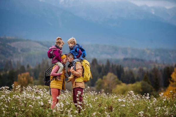 Mutlu Ebeveynler Küçük Çocukları Sonbahar Yürüyüşünde Sırtlarında Taşıyorlar Rengarenk Doğanın — Stok fotoğraf