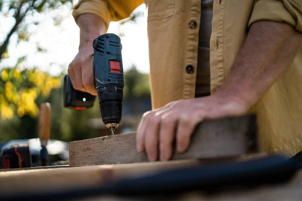一名木工木匠的特写镜头 他在户外的木工车间里用钻头操练 — 图库照片
