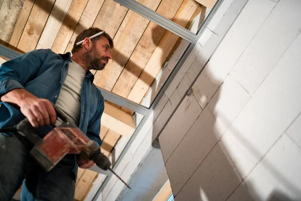 建設現場でドリルで作業する人の低角度ビュー — ストック写真